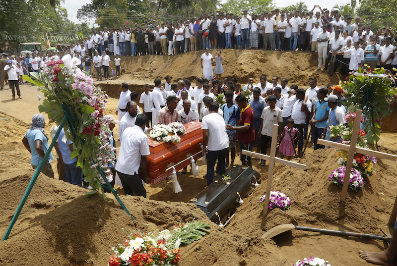 epaselect epa07522390 Relatives and friends bury the victims of a series of  bomb blasts at cemetery Don David Katuwapitiya in Colombo, Sri Lanka, 23 April 2019. According to police, at least 290 people were killed and more than 400 injured in a coordinated series of blasts during the Easter Sunday service at churches and hotels in Sri Lanka on 21 April 2019.  EPA-EFE/M.A. PUSHPA KUMARA