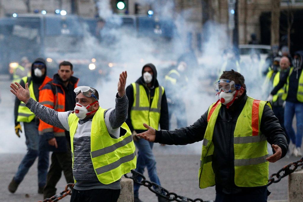 Protesters wearing yellow vests, a symbol of a French drivers' protest against higher diesel taxes, face off with French gendarmes during clashes at the Place de l'Etoile in Paris, France, December 1, 2018. REUTERS/Stephane Mahe