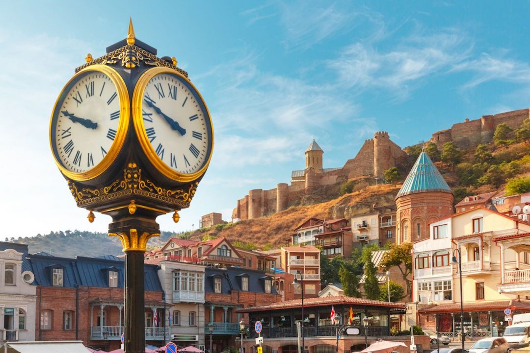 Amazing-view-of-City-clock-Old-Meidan-Square-and-Narikala-ancient-fortress-in-the-sunny-morning-Tbilisi-Georgia.