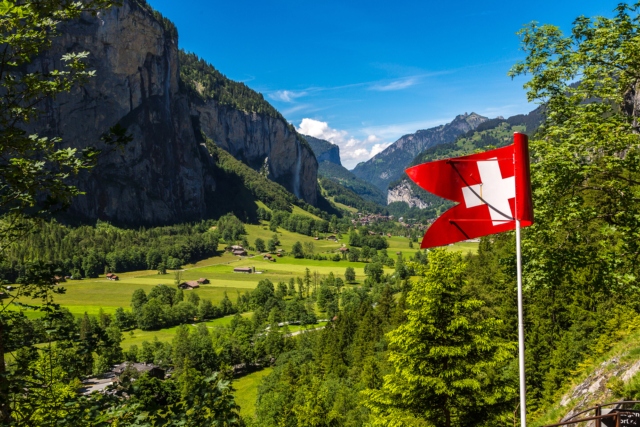 The Swiss flag and Lauterbrunnen Valley in a beautiful summer day, Switzerland