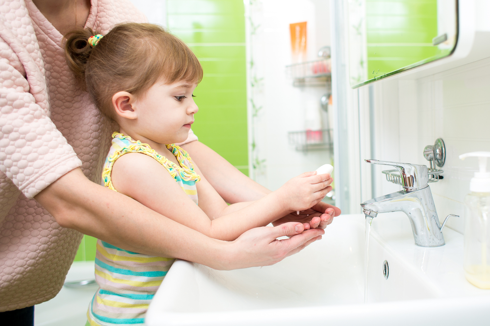 child girl  and mother washing hands with soap in bathroom