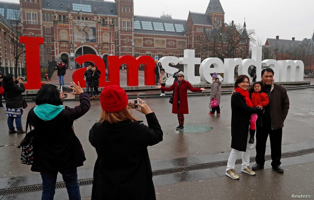 FILE PHOTO: Tourists pose for photos outside the Rijksmuseum in central Amsterdam, Netherlands, December 1, 2017.  REUTERS/Yves Herman/File Photo - RC1BB8F43A30