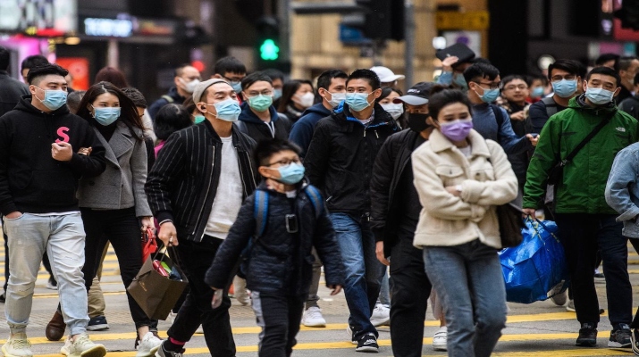 TOPSHOT - Pedestrians wearing face masks cross a road during a Lunar New Year of the Rat public holiday in Hong Kong on January 27, 2020, as a preventative measure following a coronavirus outbreak which began in the Chinese city of Wuhan. (Photo by Anthony WALLACE / AFP) (Photo by ANTHONY WALLACE/AFP via Getty Images)