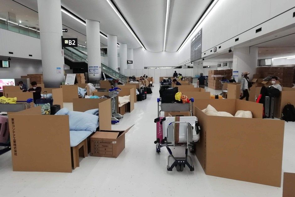 In this April 8, 2020 photo provided by Naohiro Katsuta, people wait their test results for the coronavirus at temporary beds made with cardboard boxes at Narita International Airport in Narita, near Tokyo. Cardboard boxes are being readied at Tokyo's Narita international airport for quarantine as arriving people wait for test results for the coronavirus. Shotaro Tajima, a Japanese Health Ministry official in the contagious diseases section, said people are now at nearby hotels and have not had to stay in the boxes. If cases grow, people may need to wait longer for test results, which usually come back within several hours. Japan is requiring tests for people who fly in from dozens of nations, including the U.S., China and Italy. (Naohiro Katsuta via AP)