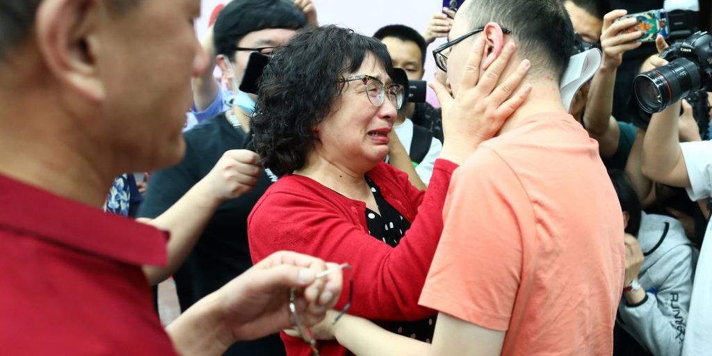 This photo taken on May 18, 2020 shows Mao Yin (R) reuniting with his mother Li Jingzhi (C) and father Mao Zhenping (L) in Xian, in China's northern Shaanxi province. - A Chinese man who was kidnapped as a toddler 32 years ago has been reunited with his biological parents, after police used facial recognition technology to track him down. (Photo by STR / AFP) / China OUT (Photo by STR/AFP via Getty Images)