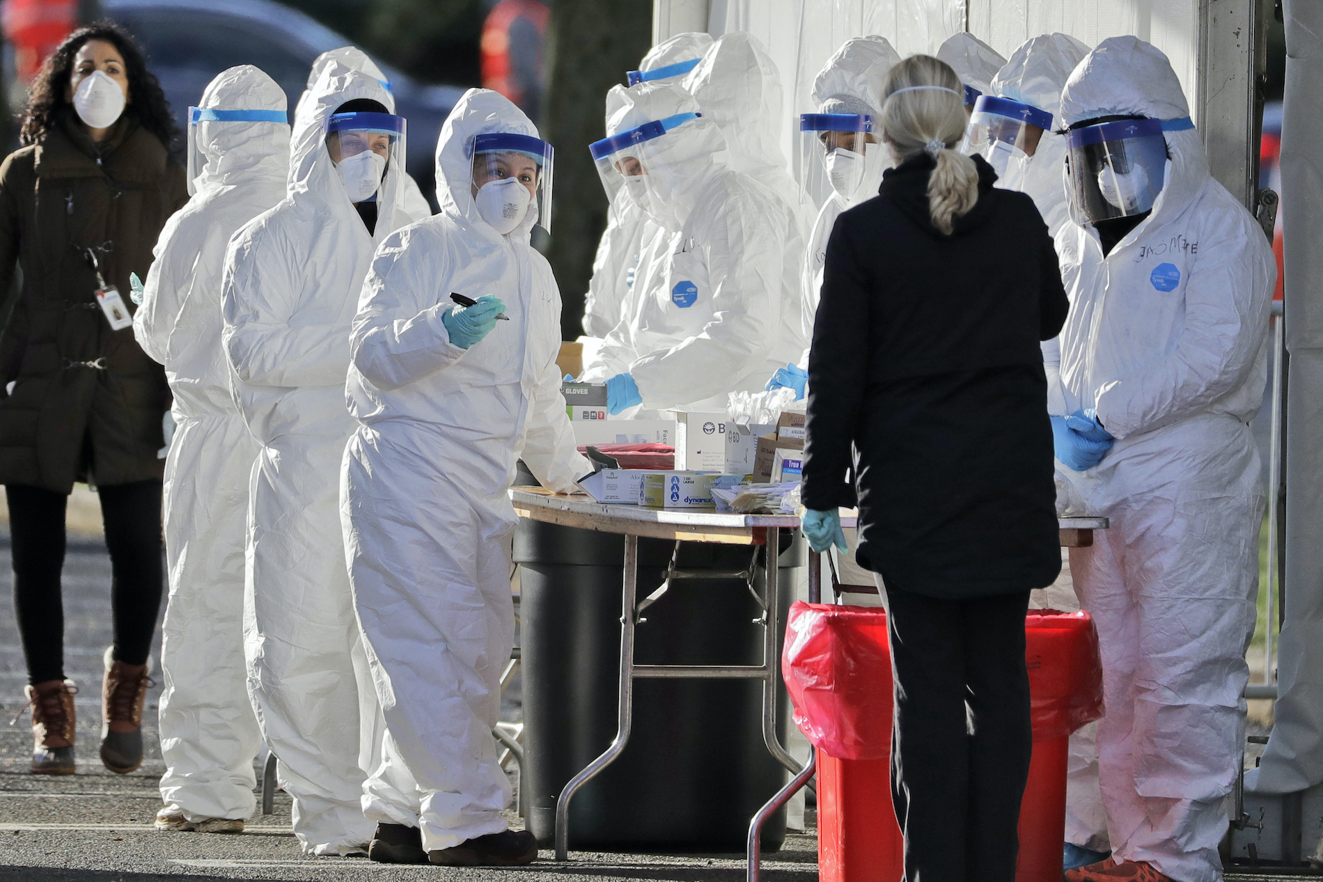 Staff in protective equipment prepare to test people at a drive-thru COVID-19 testing site at the PNC Bank Arts Center in Holmdel, N.J., Tuesday, March 24, 2020. (AP Photo/Seth Wenig)