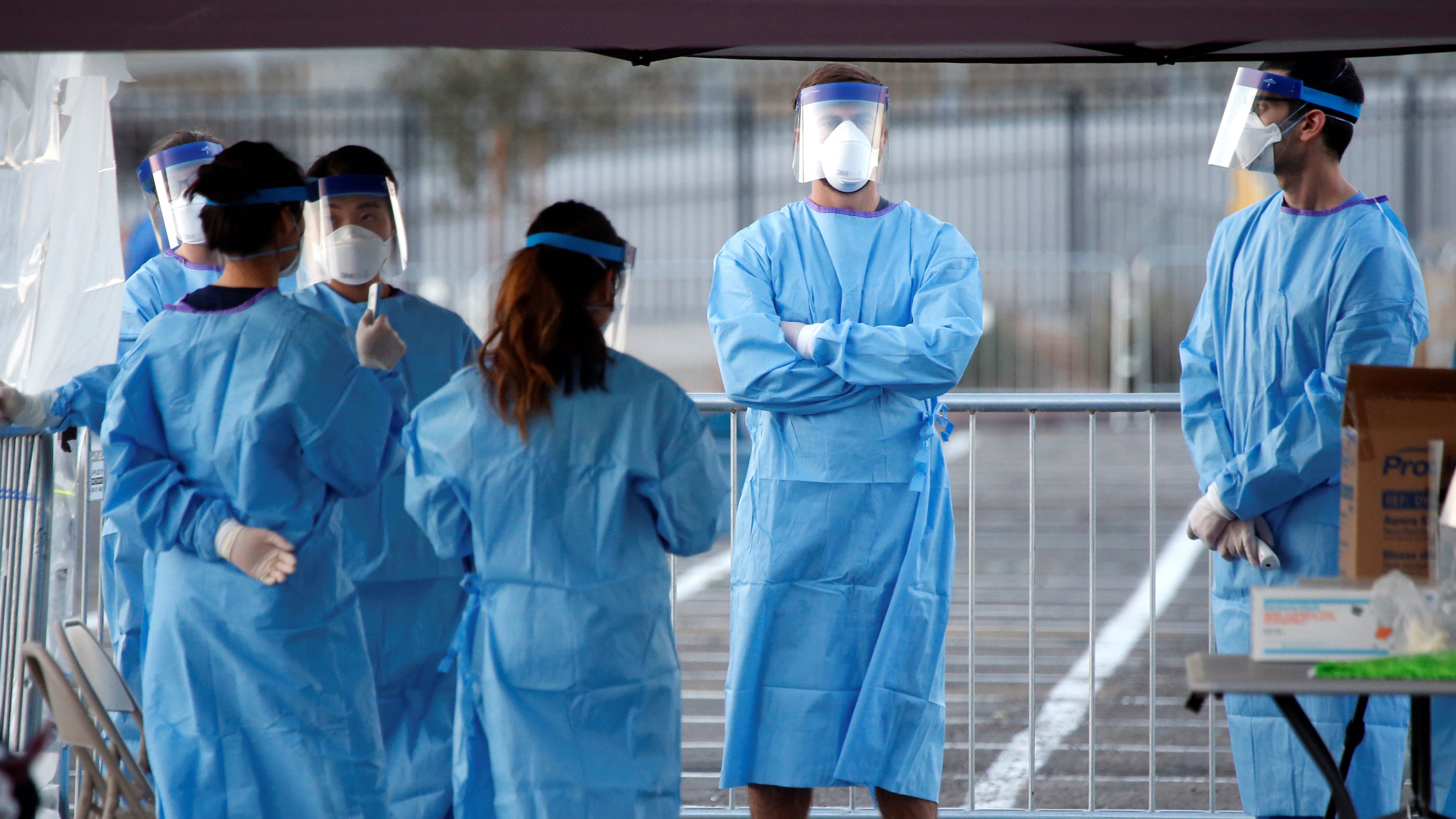 Medical students and physician assistants from Touro University Nevada wait to screen people in a temporary parking lot shelter at Cashman Center, with spaces marked for social distancing to help slow the spread of coronavirus disease (COVID-19) in Las Vegas, Nevada, U.S. March 30, 2020. REUTERS/Steve Marcus
