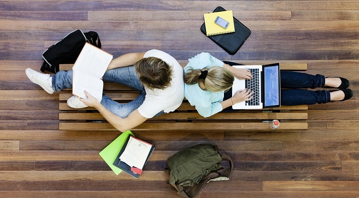 Top view of male and female university students studying