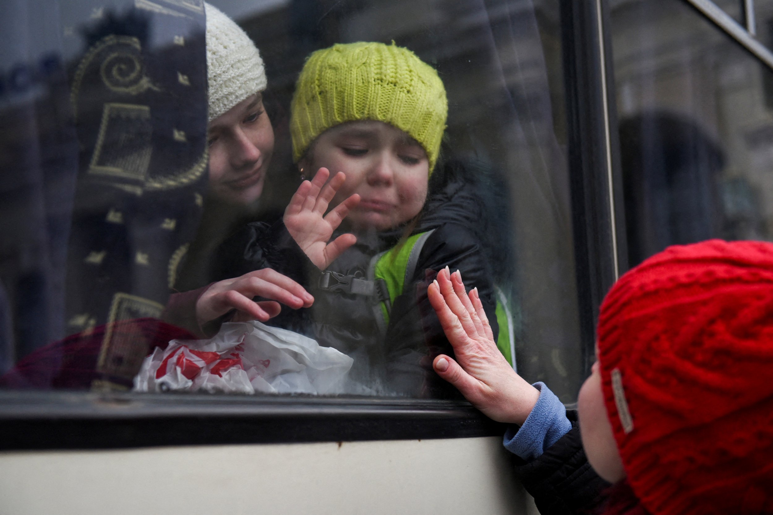 Alexandra, 12, holds her sister Esyea, 6, who cries as she waves at her mother Irina, while members of the Jewish community of Odessa board a bus to flee Russia's invasion of Ukraine, in Odessa, Ukraine, March 7, 2022. REUTERS/Alexandros Avramidis