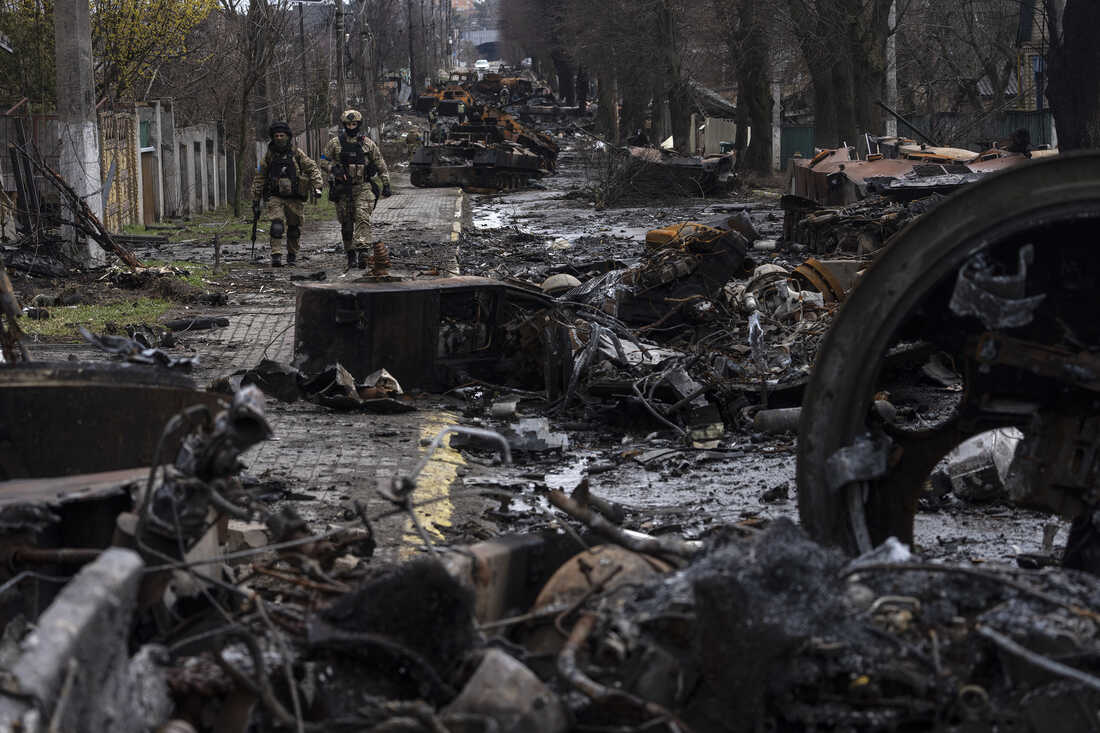 Soldiers walk amid destroyed Russian tanks in Bucha, in the outskirts of Kyiv, Ukraine, Sunday, April 3, 2022. Ukrainian troops are finding brutalized bodies and widespread destruction in the suburbs of Kyiv, sparking new calls for a war crimes investigation and sanctions against Russia. (AP Photo/Rodrigo Abd)