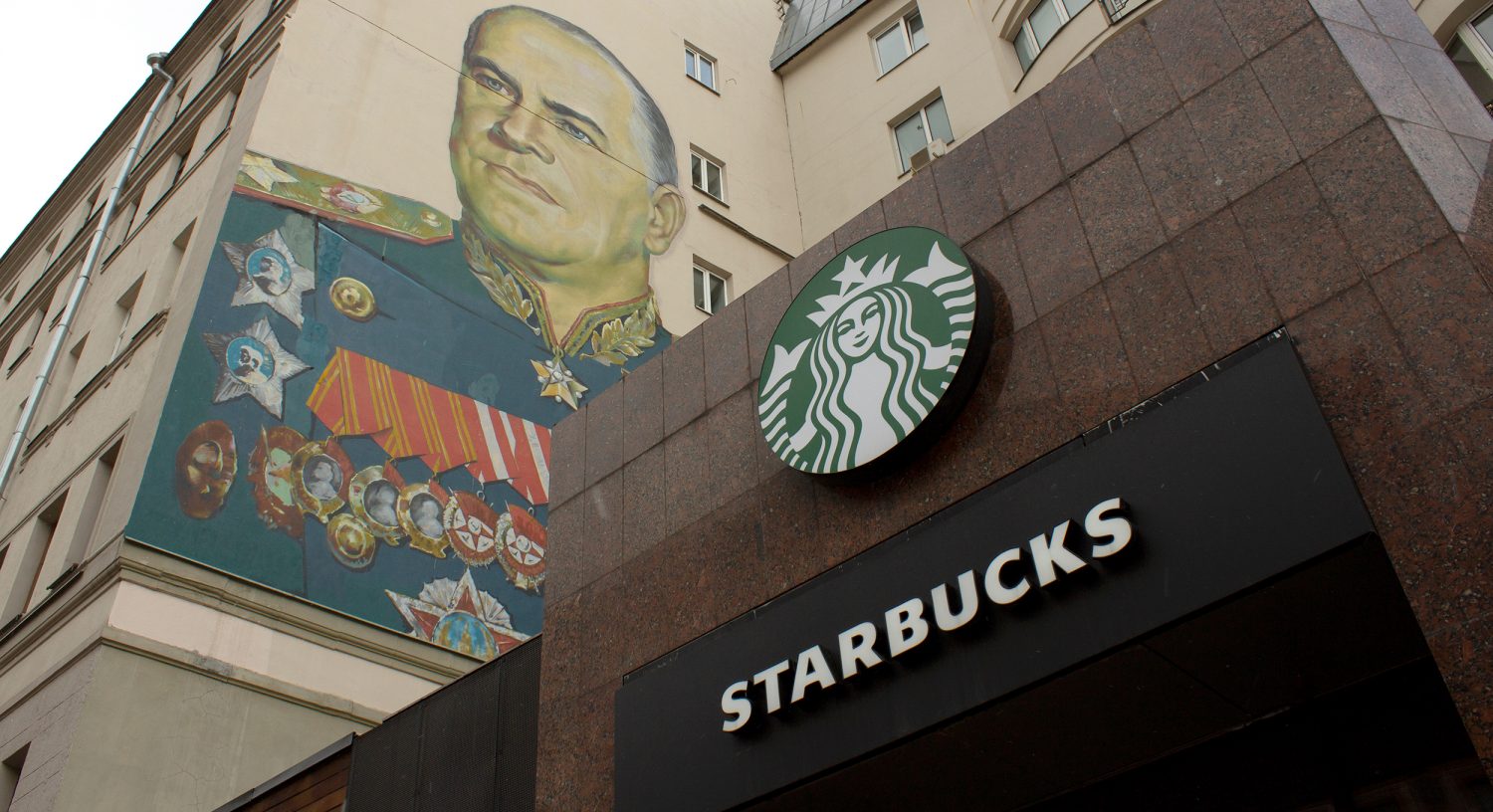 MOSCOW, RUSSIA - 2022/03/27: A Starbucks sign is seen alongside the mural of Georgy Zhukov, a Soviet general and Marshal of the Soviet Union who oversaw some of the USSRâs most decisive victories over Nazi Germany during WWII. (Photo by Vlad Karkov/SOPA Images/LightRocket via Getty Images)