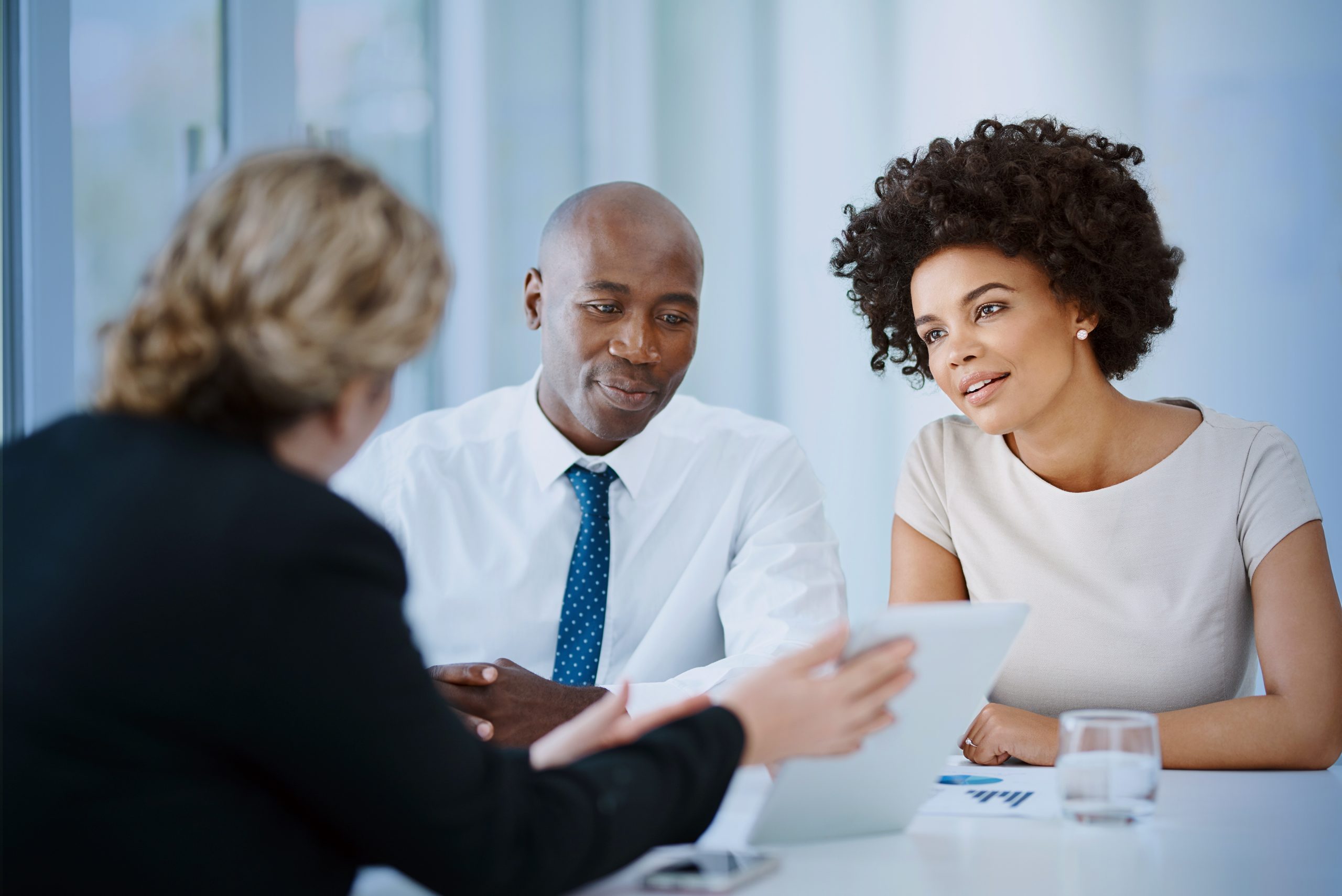 Shot of a young man and woman meeting with a financial planner in a modern office