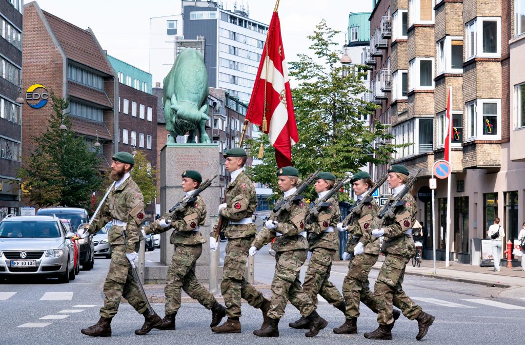 Soldiers carry the Danish flag (Dannebrog) past the sculpture The Cimbrer Bull as they parade through Aalborg, Denmark, during the Flag Day for Denmark's emissaries, on September 5, 2021. - The Flag Day honours people who are or have been sent on a mission by Denmark. - Denmark OUT (Photo by Henning Bagger / Ritzau Scanpix / AFP) / Denmark OUT (Photo by HENNING BAGGER/Ritzau Scanpix/AFP via Getty Images)