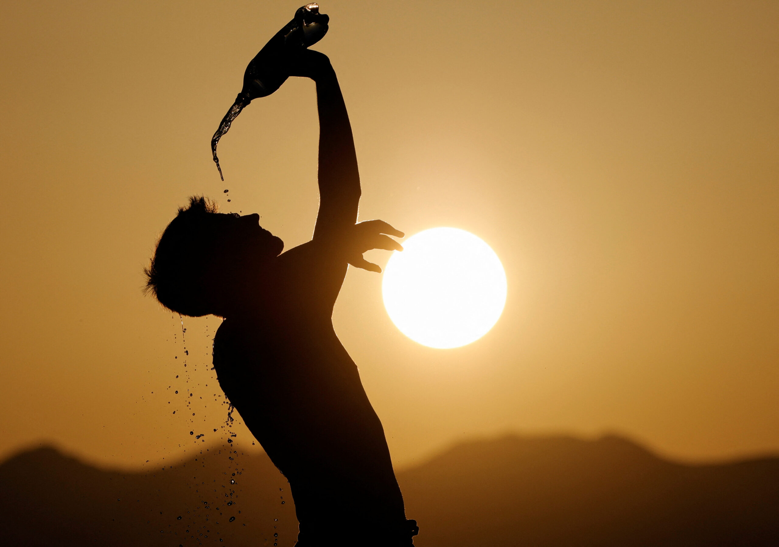 FILE PHOTO: A runner cools down with water in Skopje, North Macedonia July 12, 2023. REUTERS/Ognen Teofilovski/File Photo