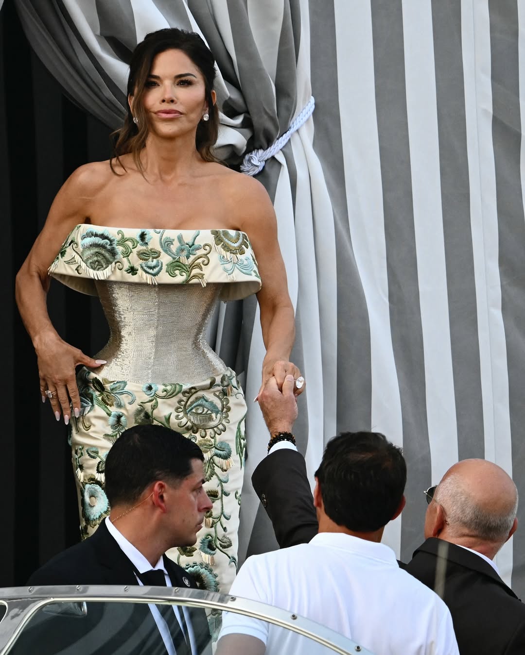 Lauren Sánchez lució un vestido de escote palabra de honor y silueta de corset en color verde metálico con bordados florales; mientras que Jeff llevó un traje marrón con camisa blanca sin corbata para dirigirse a The Madon (2)