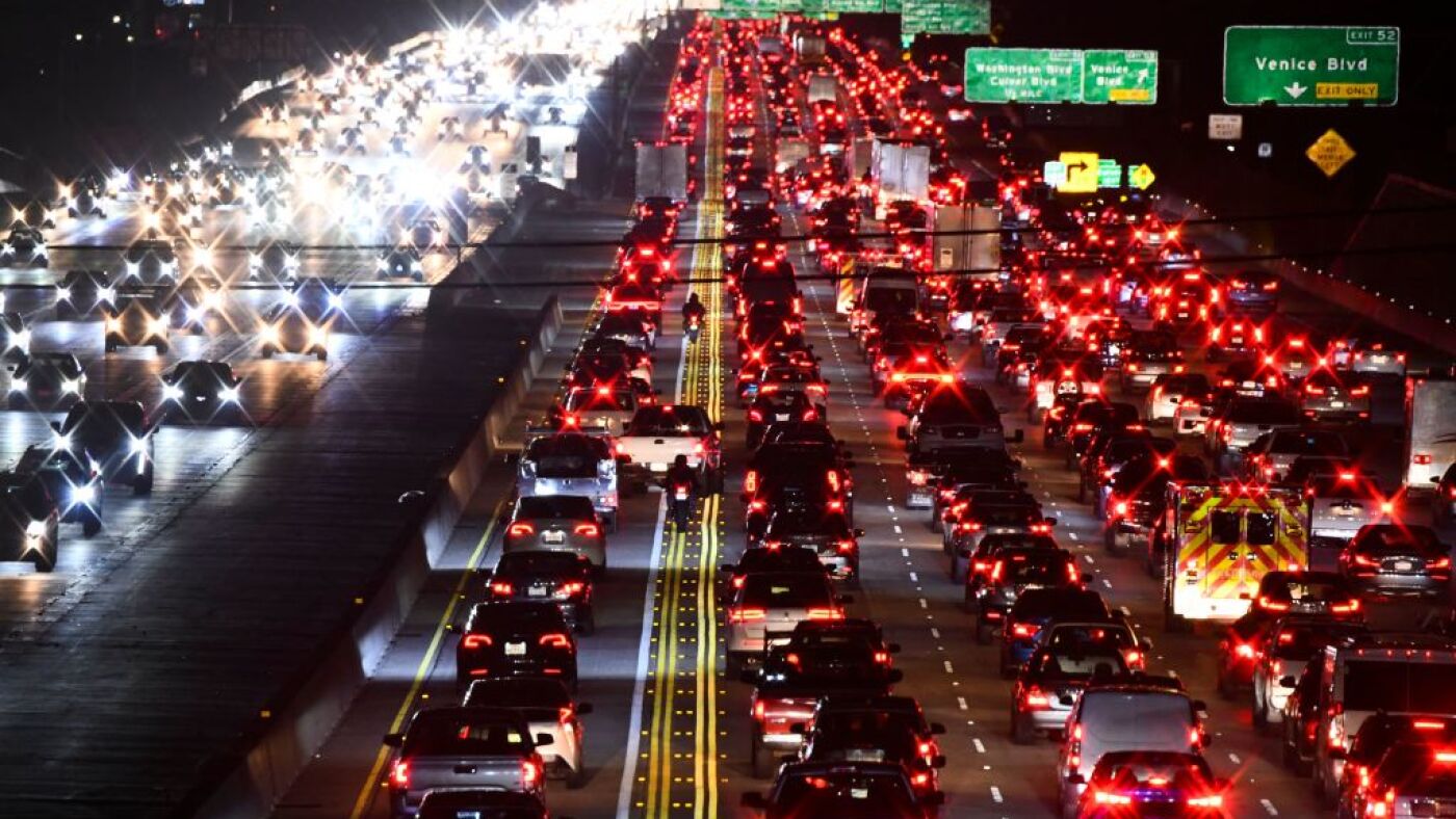 A motorcyclist avoids a collision with a pickup truck illegally changing lanes as they drive between cars, trucks, and sport utility vehicles (SUVs) on the 405 Freeway during rush hour traffic as oil and gasoline fuel prices experienced an increase on March 10, 2022 in Los Angeles, California. - US consumer prices hit a new 40-year high last month as the world's largest economy continued to be battered by a surge of inflation, which the fallout from Russia's invasion of Ukraine is expected (Photo by Patrick T. FALLON / AFP) (Photo by PATRICK T. FALLON/AFP via Getty Images)